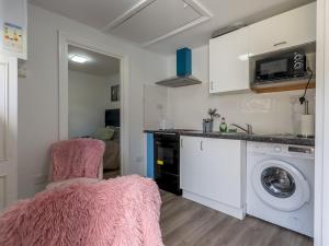 a kitchen with a washing machine and a washer at Comfortable 2 Bed Apartment- Pass the Keys in Basildon