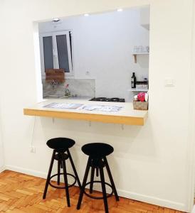 a kitchen with two bar stools at a counter at Athens Pangrati cute apt, 15 mins from metro in Athens