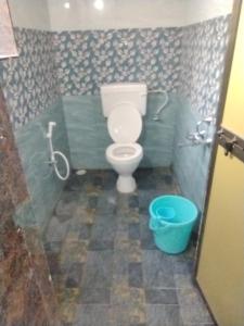 ein Badezimmer mit Toilette und blauem Eimer in der Unterkunft Annapurna beach resort in Malvan