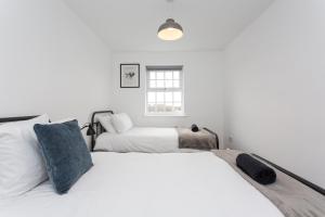 two beds in a room with white walls and a window at Lancers Close House in Leyland