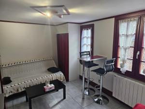 a room with a bed and a table and windows at Petit Duplex in Honfleur