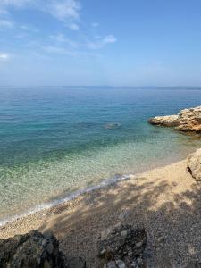 a beach with clear water and rocks on the shore at Apartman Anton in Stara Baška +3 photos