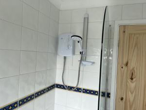 a shower in a bathroom with a shower head at 3-Bed House - Sleeps 5 with free on street parking in Leighton Buzzard +23 photos