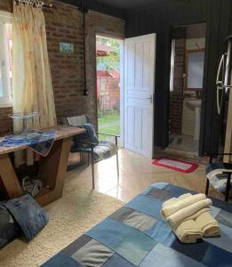 a living room with a bed and a bathroom at Hospedagem da Dona Carla in Canela
