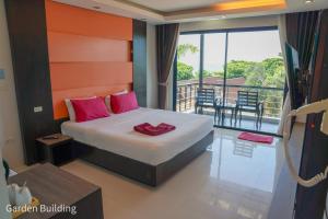 una camera da letto con balcone e letto con cuscini rossi. di Silversand Resort a Ko Samed