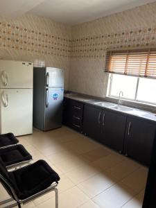a kitchen with a refrigerator and a sink at Apartment Three Oranges SH 75 E Nza Street Independence Layout Enugu in Mama