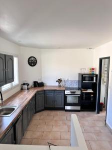 a kitchen with black appliances and wooden counter tops at Maison face au lac in Lacanau +14 photos