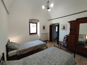 a bedroom with two beds and a dresser at AbruzzoMio Alloggi Agrituristici in Goriano Valli