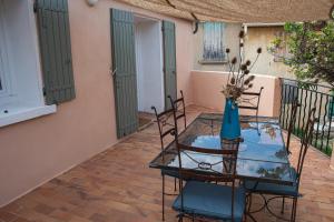 una mesa de cristal con sillas y un jarrón azul. en Maison de la Porte des Loups dans le Ventoux, en Bédoin