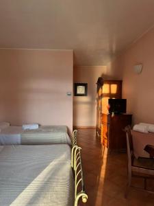 a hotel room with two beds and a television at Motel Cosmera in Savigliano