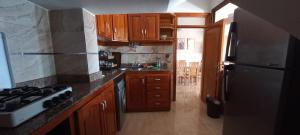 a kitchen with wooden cabinets and a black refrigerator at Appartement vu plage kemado in Al Hoceïma