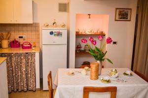 マンドゥーリアにあるCorte Schiavoni B&Bのキッチン(テーブル、白い冷蔵庫付)