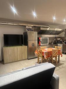 a kitchen with a table with chairs and a refrigerator at Casa Maya in Stazzona