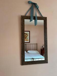 a mirror with a blue bow on a wall at Motel Cosmera in Savigliano