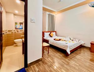 un dormitorio con una cama y un baño en Đức Phúc Hotel, en Ho Chi Minh