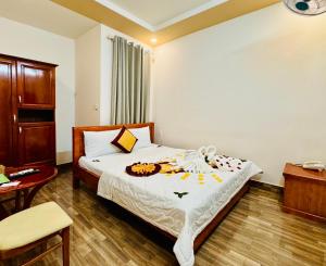 Un dormitorio con una cama, una silla y una mesa. en Đức Phúc Hotel, en Ho Chi Minh