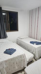 een kamer met twee bedden en een raam bij Paraíso Malawí Flat Muro Alto in Porto De Galinhas +48 foto's