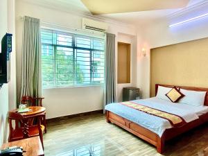 Un dormitorio con una cama y una ventana grande. en Đức Phúc Hotel, en Ho Chi Minh