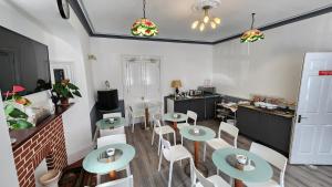 a room with tables and chairs and a kitchen at Gatwick Castle B&B in Horley