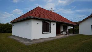 a small white house with a red roof at Andreas Apartman in Keszthely