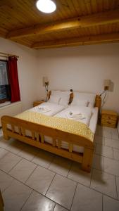 a large wooden bed in a room with a ceiling at Andreas Apartman in Keszthely +44 photos
