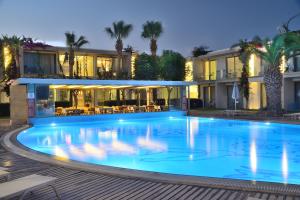 a large swimming pool in front of a building at Lugga Boutique Hotel & Beach in Ortakent