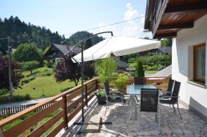 eine Terrasse mit einem Tisch und einem Sonnenschirm in der Unterkunft Anna's House in Bled