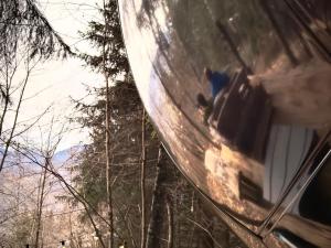 a reflection of two people in the window of a car at Mirror globe Kandasphere in Saint-Gervais-les-Bains