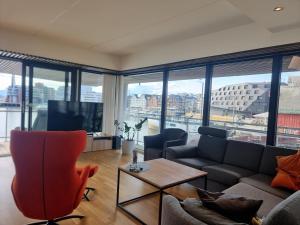 a living room with a couch and a tv at The Seaview Suite - Tromsø harbour! in Tromsø