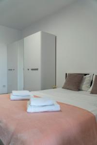 a bedroom with two beds with white cabinets and towels at Studio Accommodation City Center in Iaşi