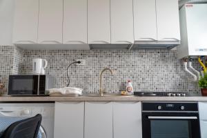 a kitchen with white cabinets and a sink at Studio Accommodation City Center in Iaşi