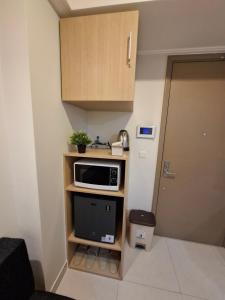 a small kitchen with a microwave on a shelf at Jakarta goldcoast seaview apartment in Jakarta +9 photos