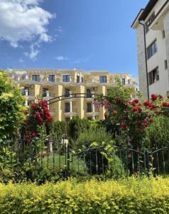 a building with a fence and flowers in front of it at Horizon Apartament Gut in Sveti Vlas