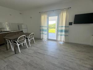a dining room with a table and chairs and a door at Garden Hotel Alghero in Fertilia