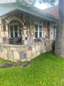 una casa de piedra con dos bancos en un muro de piedra en The Kaiser House, en Harper