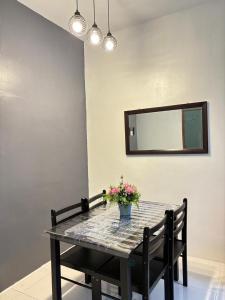 ein Esstisch mit einer Vase mit Blumen darauf in der Unterkunft KH Homestay 2 Seri Manjung in Seri Manjung + 3 Fotos