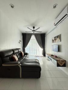 ein Wohnzimmer mit einer Couch und einem Deckenventilator in der Unterkunft KH Homestay 2 Seri Manjung in Seri Manjung