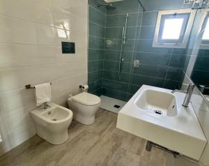 a bathroom with a toilet and a sink at Garden Hotel Alghero in Fertilia