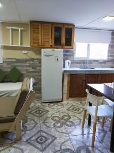 Il comprend une cuisine équipée d'un réfrigérateur et d'une table. dans l'établissement Cabaña Vivir, à El Chalten