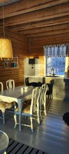 a dining room with a white table and chairs at Kieloranta in Kuopio