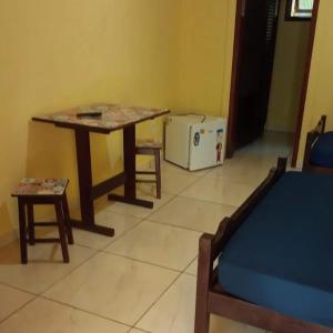 a room with a table and a table and a microwave at Ubatuba's Surf hotel in Ubatuba