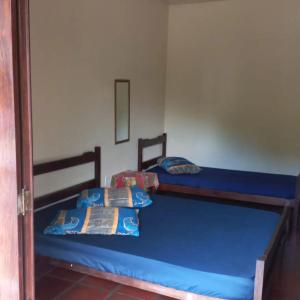 two beds in a room with blue sheets at Ubatuba's Surf hotel in Ubatuba