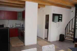 a kitchen with red cabinets and a white wall at Vikendica Mandic in Gornji Volari
