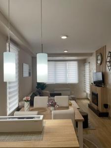 a dining room and living room with a table and chairs at Apartman Jellena centar Zlatibora in Zlatibor