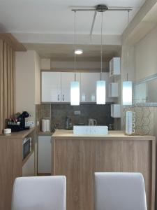 a kitchen with two white chairs and a counter at Apartman Jellena centar Zlatibora in Zlatibor