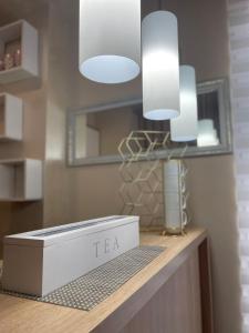 a box on a counter with two lights and a mirror at Apartman Jellena centar Zlatibora in Zlatibor