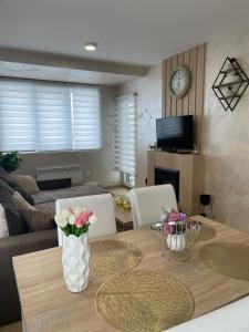 a living room with a table with flowers on it at Apartman Jellena centar Zlatibora in Zlatibor +29 photos