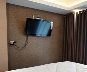 a tv on the wall of a hotel room at Apartement Grand Asia Afrika Bandung by House Of Tofi in Bandung