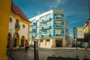 a blue hotel on a street in a city at Hotel Leiria Classic in Leiria