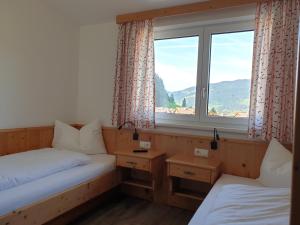 due letti singoli in una stanza con finestra di Hanneshof a Flachau